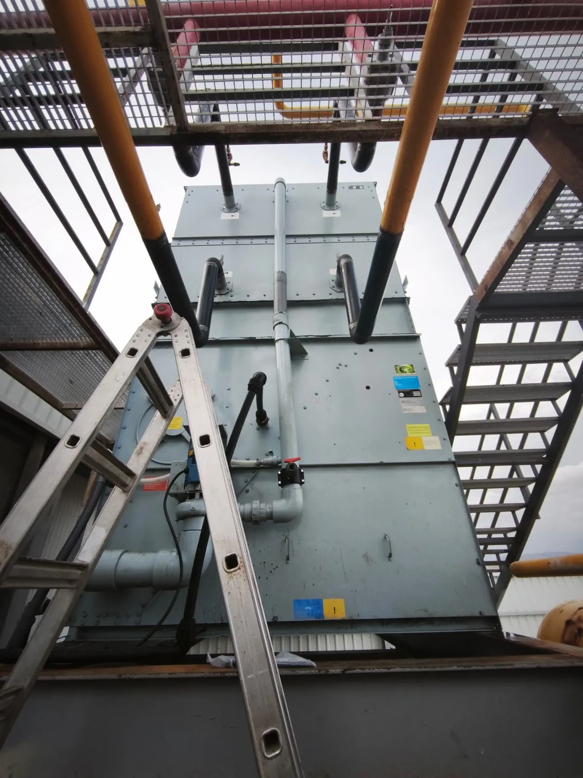 Condensador evaporativo instalado en la cubierta de una nave, con escalera de acceso para su revisión